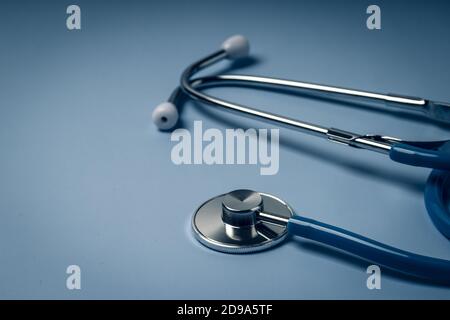 Blue stethoscope  on blue medical background. Medical insurance concept. Dramatic light Stock Photo