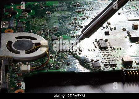 use a soldering iron to solder the electronic part to the Board. Computer repair. Macrophotography. Stock Photo