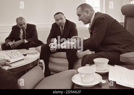 Roy Wilkins and Dr. Martin Luther King, Jr. meet with President Lyndon B. Johnson in the Oval Office of the White House on January 18, 1964. Stock Photo