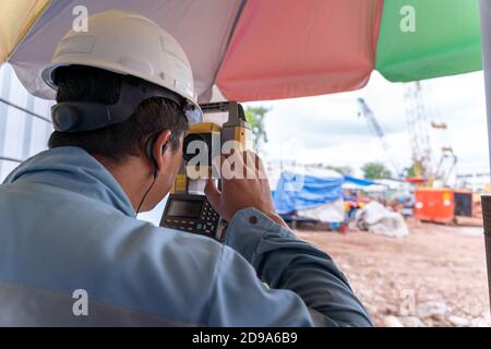 Surveyor builder engineer theodolite equipment during surveying work in new construction site Stock Photo