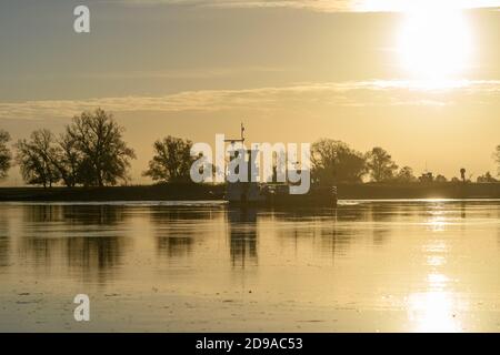 04 November 2020, Saxony-Anhalt, Rogätz: The Elbe ferry Rogätz sets the first commuters across the river at sunrise. A sunny day lies ahead for Central Germany. It will be colder than in the last few days. Photo: Klaus-Dietmar Gabbert/dpa-Zentralbild/ZB Stock Photo