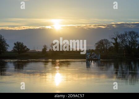 04 November 2020, Saxony-Anhalt, Rogätz: The Elbe ferry Rogätz sets the first commuters across the river at sunrise. A sunny day lies ahead for Central Germany. It will be colder than in the last few days. Photo: Klaus-Dietmar Gabbert/dpa-Zentralbild/ZB Stock Photo