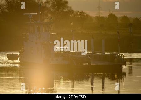 04 November 2020, Saxony-Anhalt, Rogätz: The Elbe ferry Rogätz sets the first commuters across the river at sunrise. A sunny day lies ahead for Central Germany. It will be colder than in the last few days. Photo: Klaus-Dietmar Gabbert/dpa-Zentralbild/ZB Stock Photo