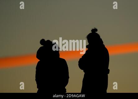 Newtown Linford, Leicestershire, UK. 4th November 2020. UK weather.  Women watch sunrise from Old John in Bradgate Park. Credit Darren Staples/Alamy Live News. Stock Photo