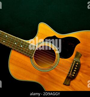 Aerial view of a wooden classical acoustic guitar isolated on a black background. Stock Photo