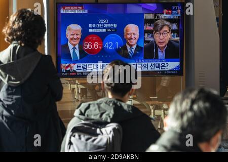 People at Seoul Train Station watch TV news report about the US Presidential election comparing Joe Biden with Donald Trump on 2020 US presidential election day. Stock Photo