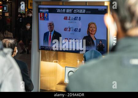 People at Seoul Train Station watch news report about the US presidential election comparing Hillary Clinton with Donald Trump on 2020 US presidential election day.. Stock Photo