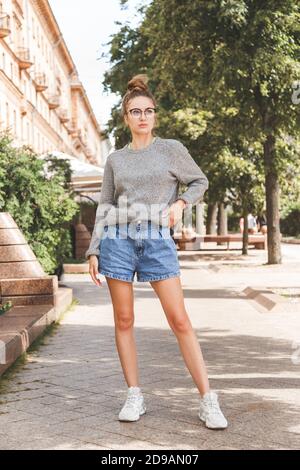 Street summer fashion portrait of young millennial girl in glasses and casual clothes Stock Photo