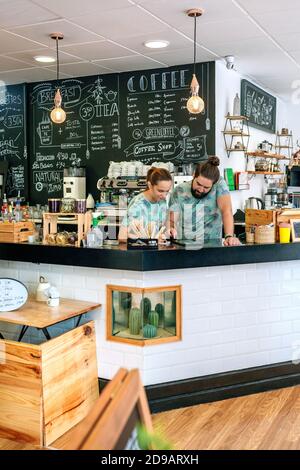 Owners of a coffee shop working looking at the tablet Stock Photo