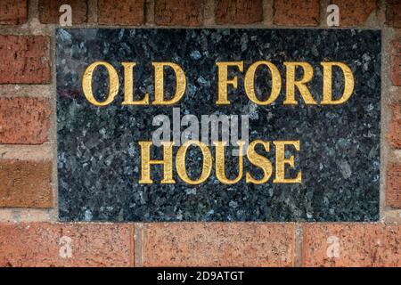 Gold lettering on marble house name sign Stock Photo