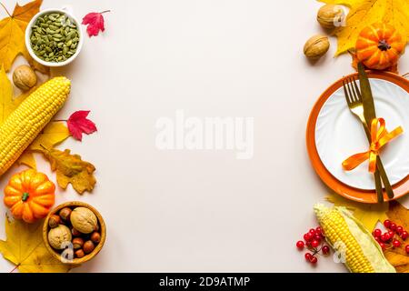 Thanksgiving day dinner table, top view . Autumn vegetables on plate with cutlery Stock Photo