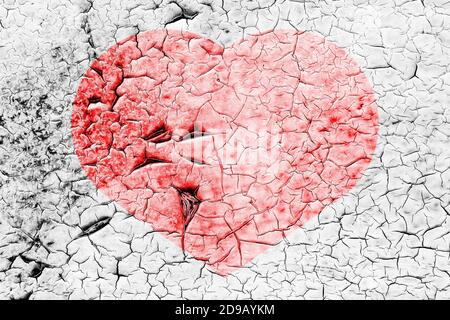 Red heart on a cracked texture. The concept of broken heart, end of love and disappointment.
