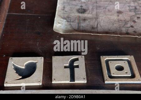 Set of popular social media wooden icons over a wood table and Vintage still-life of old maps Stock Photo