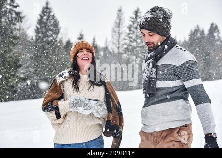 Cheerful young Caucasian couple having a cup of coffee in the snow Stock Photo