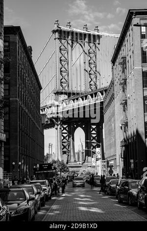 NEW YORK, USA - Sep 22, 2017: Black and white image ofManhattan Bridge with the Empire State building and brick wall buildings viewed from Dumbo, Broo Stock Photo