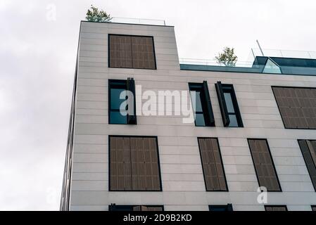 Madrid, Spain - October 4, 2020: New residential building with stone ventilated facade and wooden lattice shutters Stock Photo