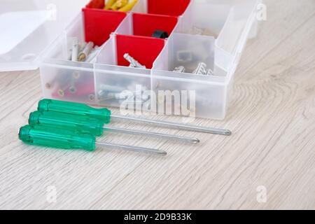 Box with special tools, parts and screwdrivers, closeup. Tools on light wooden background. Diy repairs. Copy space. Stock Photo
