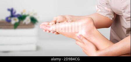 Close up, woman's legs during foot massage at spa salon. Foot massage is the best way to relieve fatigue Stock Photo