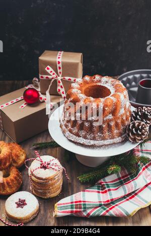 Assortment of homemade Christmas desserts and gift boxes on a rustic wooden table Stock Photo