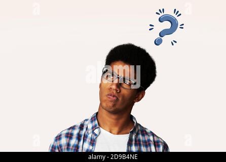 Thoughtful black man with question mark over his head having doubts about his problem solution, creative collage Stock Photo