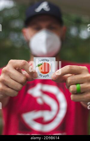 LAWRENCEVILLE, UNITED STATES - Oct 29, 2020: Lawrenceville, GA / United States - October 29 2020:  A Georgia voter holds up his 'I Voted' sticker afte Stock Photo