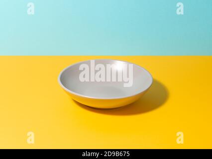 Gray deep plate on a colorful table Stock Photo