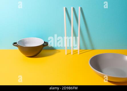 Bowl, deep plate and plastic straws on colorful background Stock Photo