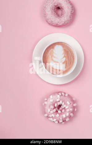 Flat lay composition with two donuts and cup of coffee on pink background Stock Photo