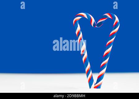 Christmas lollipops on a blue background. Heart on a blue background. Heart made of lollipops. Heart for valentine's day Stock Photo