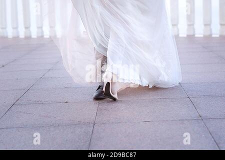 A couple of the bride and groom dance a wedding dance. Dance of the newlyweds. Legs close-up. Stock Photo
