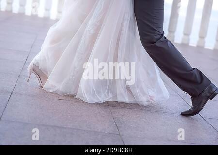 A couple of the bride and groom dance a wedding dance. Dance of the newlyweds. Legs close-up. Stock Photo