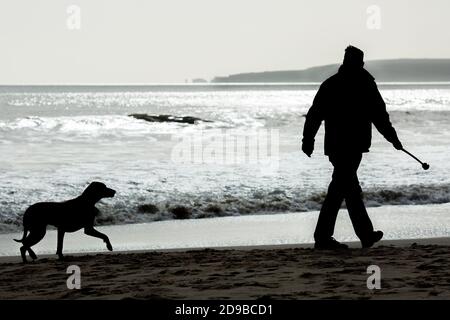 Walking a dog on a February morning on the beach at Branksome Chine in Poole in Dorset . 24 February 2015. Photo: Neil Turner Stock Photo