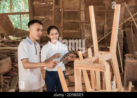 two young entrepreneurs working together in business when looking at furniture design at the workshop Stock Photo