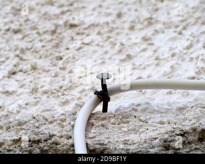 cable and spike on a wall detail Stock Photo