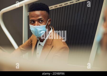 Business Couple Wearing Masks Meet On Office Stairs During Break In Office During Pandemic Stock Photo