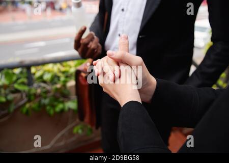 Close Up Of Businesspeople Using Hand Sanitiser During Health Pandemic Stock Photo