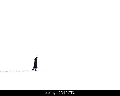 Side view of a woman walking in the snow, South Korea Stock Photo