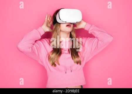 shocked beautiful woman in vr headset on pink background Stock Photo