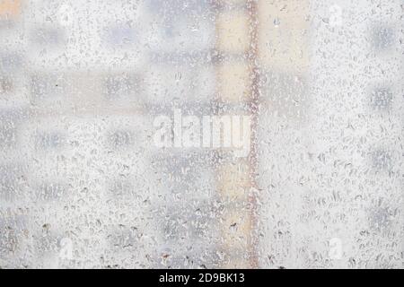 View through a rainy window on a blurred house. Bad rainy weather. Stock Photo