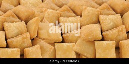 Shakkar pare also know as shakarpali,skarpara,typical sweet gujarati deep fried snacks made from wheat flour and jaggery. background image. Stock Photo