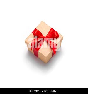 Isolated craft gift box with red ribbon as presenf for Christmas, new year, mothers day, anniversary, birthday on white background. Flat lay top view Stock Photo