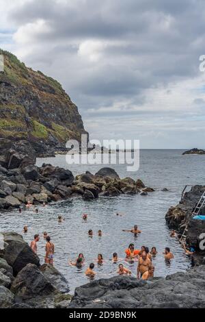 SAO MIGUEL, AUGUST 29, 2020: Natural volcanic rocks near Ponta da Ferraria, the place where hot springs mix with seawater in Sao Miguel island, Azores Stock Photo