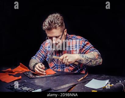 Leather Artist producing leather workpiece at the shop Stock Photo