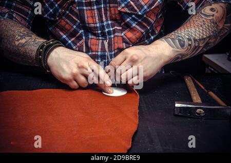 Worker of leather producing leather goods Stock Photo