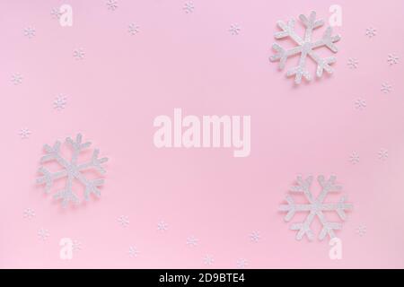 Christmas composition. Christmas frame made of snowflakes on pastel pink background. Christmas or New Year 2021 minimal concept. Flat lay, copy space Stock Photo