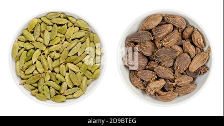 Green and black cardamom pods in white bowls. Processed fruits and seeds of Elettaria cardamomum and Amomum subulatum, both used as spice. Stock Photo