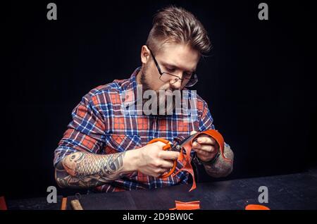 Craftsman forms new leather product in his work area Stock Photo