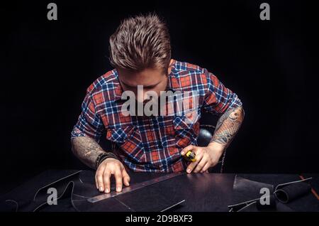 Worker of leather producing leather workpiece Stock Photo