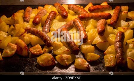Traditional Nuremberg or Bavarian sausages baked in the oven with potatoes