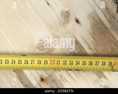ruler on the background of the wood board. joinery and tools. working with a tree during coronavirus isolation. free space for text Stock Photo